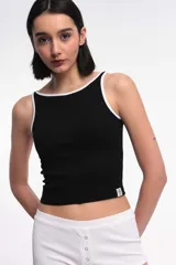 Musculosa tipo rib blanca con escote bote, corte al cuerpo y ribetes en contraste de color negro.