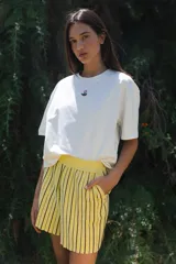 Short amarillo con rayas verticales negras, tejido con lurex y cintura elástica.