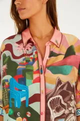 Camisa de viscosa con estampado ilustrado de escenas de Río de Janeiro, que incluye playa, morros y elementos tropicales. Cuenta con cuello camisero, botones frontales y mangas cortas holgadas.