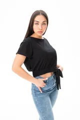 Remera negra de algodón y elastano, con escote redondo y corte crop con nudo en la cintura.