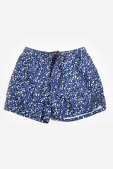 Short de baño con estampado de limones y hojas sobre fondo azul, con cintura elástica ajustable mediante cordón, bolsillos laterales y logo de goma aplicado en la pierna.