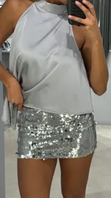 Minifalda de tiro bajo completamente cubierta de lentejuelas plateadas brillantes.