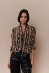 Blusa de gasa estampada con diseño animal print en tonos marrones y grises. Presenta cuello Mao, frente acordonado con cutouts simulados y mangas 3/4 con puños elásticos.