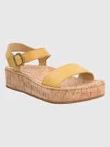 Sandalias Hush Puppies modelo Zug de cuero color amarillo, con plataforma de corcho, tira frontal ancha y tira al tobillo con cierre de hebilla metálica.