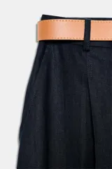 Pantalón tobillero azul marino de tiro medio, con pinzas delanteras, bolsillos frontales, falsos bolsillos con solapa en la espalda y cierre frontal con cremallera, botón y gancho. Incluye cinturón de cuero sintético tostado con hebilla metálica dorada.