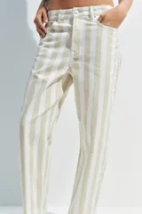 Jeans de tiro medio con corte tapered, diseño de cinco bolsillos y cierre frontal con cremallera y botón. Presenta un estampado de rayas verticales a contraste en tonos claros.