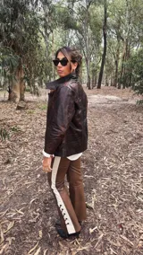 Campera de cuero con efecto envejecido en tonos marrones, de calce relajado y estructurado, con cuello alto y cierre frontal.