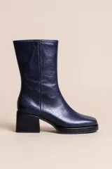 Botas de caña media en cuero azul oscuro con textura arrugada, diseño de punta cuadrada, taco cuadrado y cierre lateral.