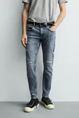 Jeans skinny fit de corte ajustado y tiro medio en color negro con efecto lavado y detalles desgastados. Confeccionados en tejido elástico con mezcla de algodón, presentan diseño clásico de cinco bolsillos y cierre frontal con cremallera y botón.