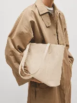 Cartera tipo tote de cuero natural, con diseño minimalista, doble asa de hombro y cierre mediante broche. Incluye bolsillo interior y porta llaves.