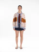 Cardigan tejido de punto jacquard en tonos bordó y rojo con rayas, de corte oversize, cuello redondo y cierre frontal con botones carey. Presenta detalles bordados en contraste y monograma en la espalda.