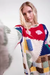 Sweater tejido a mano de lana merino, de diseño holgado con cuello redondo y mangas largas, con un colorido patrón de intarsias que representa escenas de paisajes con casas, cactus y flores.