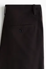 Pantalón negro de corte holgado con diseño de piernas globo, pinzas en la cintura y puños ceñidos en los tobillos.