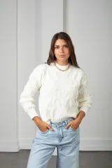 Sweater de punto color blanco, con cuello redondo y diseño de textura trenzada en relieve. Presenta mangas largas con puños ajustados y corte clásico.