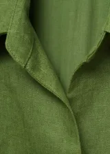 Mono largo color verde oliva, de lino, con corte camisero, cuello clásico, cierre frontal cruzado, sin mangas, cinturón trenzado desmontable y bolsillos laterales.