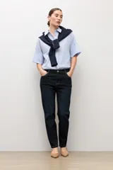 Camisa celeste con rayas blancas, de manga corta y cuello camisero.