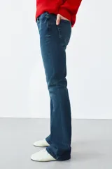 Jeans bootcut de tiro medio color azul oscuro, con cinco bolsillos y pespuntes a contraste. Cierre frontal con cremallera y botón.