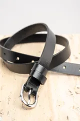 Cinto de cuero negro con hebilla metálica plateada.