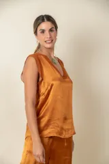 Blusa blanca de seda viscosa con escote en V y mangas cortas con detalle de gasa.