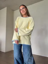 Sweater de punto jersey de algodón color amarillo con silueta oversize, mangas acampanadas y cuello a la base. Presenta terminaciones hechas a mano en crochet a contratono en color celeste con detalles de lurex.