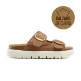 Sandalias de cuero color marrón con plataforma de corcho y suela blanca. Presentan dos tiras anchas con hebillas metálicas ajustables.