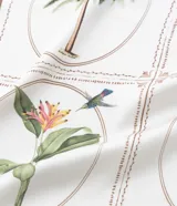 Pañuelo de poliéster satinado, color crema, con estampa botánica en tonos verdes y marrones, y bordes en color marrón oscuro.