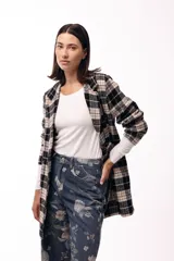 Tapado de corte recto con estampado de cuadros tartán en tonos negro y beige. Presenta solapas amplias, cierre frontal y diseño de largo medio.