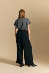 Pantalón ancho color marrón, de silueta moderna y calce cómodo, con diseño limpio y fluido. Presenta cierre frontal con botón y cordones ajustables en la cintura.