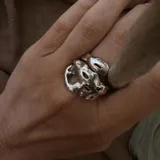 Anillo de diseño orgánico con forma irregular que evoca texturas marinas, con estructura abierta y acabado brillante.