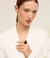 Maxi anillo bicolor de diseño ancho y orgánico, con una mitad en metal dorado con acabado texturizado y la otra mitad en resina negra lisa.