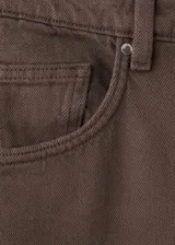 Jeans balloon de tiro medio en color marrón, de diseño largo con cinco bolsillos, trabillas y bajo vuelto. Cuenta con cierre delantero de cremallera y botón.