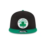 Gorra New Era modelo 9Fifty con diseño de visera plana, corona negra y visera verde. Presenta el logo de los Boston Celtics bordado en relieve sobre un parche circular blanco en el frente y el logo de la marca bordado en el lateral.