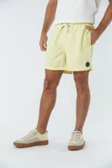 Short de baño liso con cintura elástica y cordón de ajuste. Cuenta con dos bolsillos laterales, un bolsillo posterior y un aplique de logo en goma en la pierna.