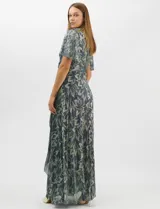 Vestido largo de fiesta con diseño cruzado, escote en V y drapeado lateral en la cintura. Presenta mangas cortas acampanadas y falda amplia con caída fluida. Confeccionado en tejido liviano con acabado plisado y estampado floral metalizado.