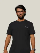 Remera negra de manga corta con estampado gráfico en la espalda que incluye la frase 'Bo, hay pique!' y dibujos de peces con una caña de pescar.