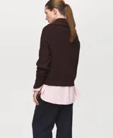 Jersey de punto grueso marrón con cuello de solapa ancha, cierre frontal de cremallera y manga larga.