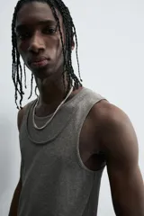 Camiseta sin mangas (tank top) negra, de corte slim fit, con cuello redondo de efecto doble.