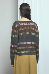 Cardigan de punto marrón con escote en V y cierre frontal con tiras para atar. Presenta diseño de rayas horizontales con patrón en zigzag de colores vibrantes como naranja, verde lima, azul y rosado.