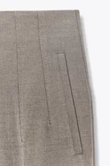 Pantalón blanco de vestir, de tiro alto y corte recto. Presenta bolsillos delanteros de vivo y cierre frontal con cremallera, botón interior y gancho metálico.