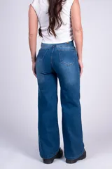 Jean wide leg de tiro alto en color azul, con cierre frontal de cinco botones, bolsillos clásicos y corte extraholgado desde el muslo hasta el bajo.