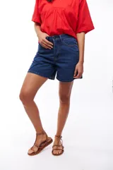 Bermuda de jean azul oscuro, tiro alto y corte recto.