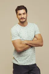 Remera de cuello redondo y manga corta, color beige con estampado de pequeños motivos playeros.
