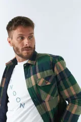 Sobrecamisa de viyela a cuadros rojos y azules con interior capitoneado, corte regular, manga larga, cierre con botones, bolsillos frontales y logo en grifa de cuero.
