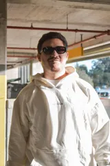 Hoodie canguro blanco de diseño oversize, con capucha, bolsillo frontal tipo koozban y sutil bordado monocromático en el pecho.