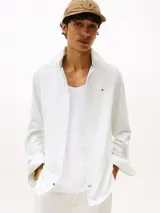 Camisa de manga larga con diseño de rayas finas, confeccionada en mezcla de algodón regenerativo y elastano. Presenta un corte slim fit, cuello clásico, cierre con botones, puños abotonados y logo de Tommy Hilfiger bordado en el pecho.