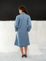 Tapado de denim celeste con cuello con pliegues y corte recto.