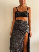 Pollera larga negra cubierta de lentejuelas, con tajo lateral alto.
