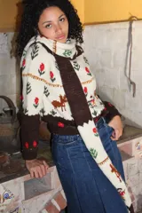 Sweater de punto jersey tejido a mano en 100% lana merino, de diseño multicolor con motivos de ciervos, árboles y flores bordados. Presenta cuello alto y puños en color marrón oscuro.