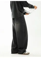 Pantalón de jean negro con lavado oscuro y efecto desgastado, de corte muy ancho (baggy) y tiro medio/alto con cintura elástica. Presenta bolsillos delanteros y traseros.
