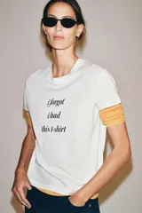 Camiseta blanca de manga corta y cuello redondo, con estampado frontal de texto en color negro que dice "i forgot i had this t-shirt".